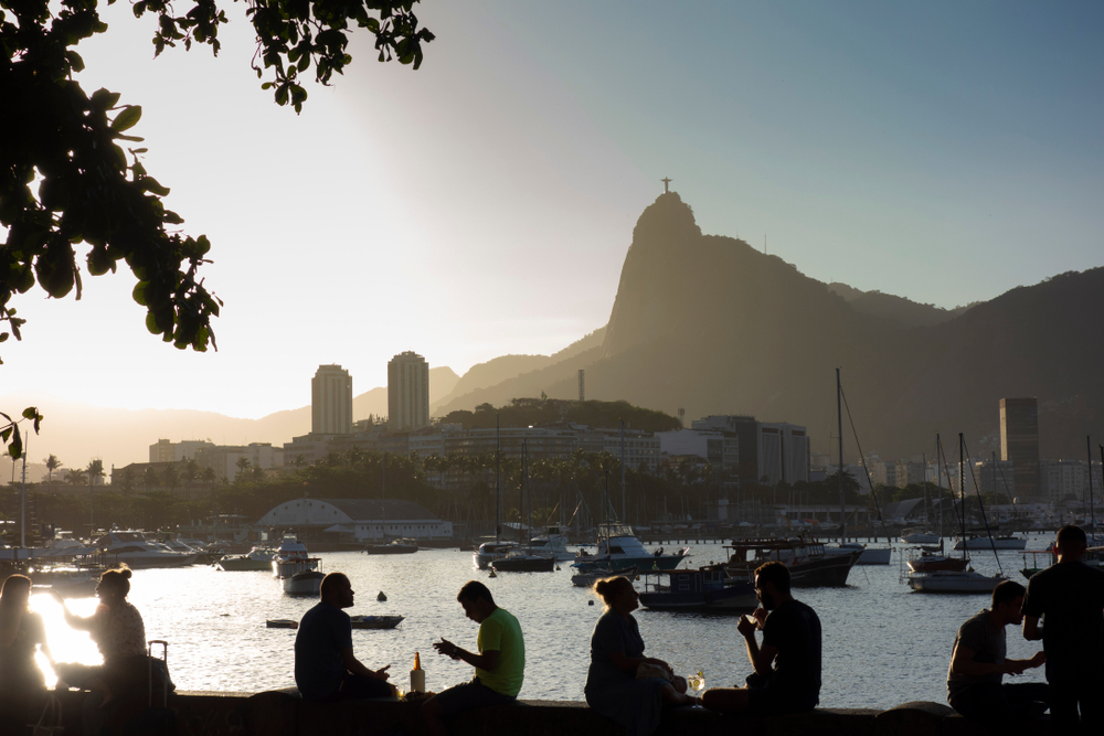 Atardecer en la Mureta da Urca con gente tomando algo y vistas al Cristo Corcovado en Río de Janeiro.