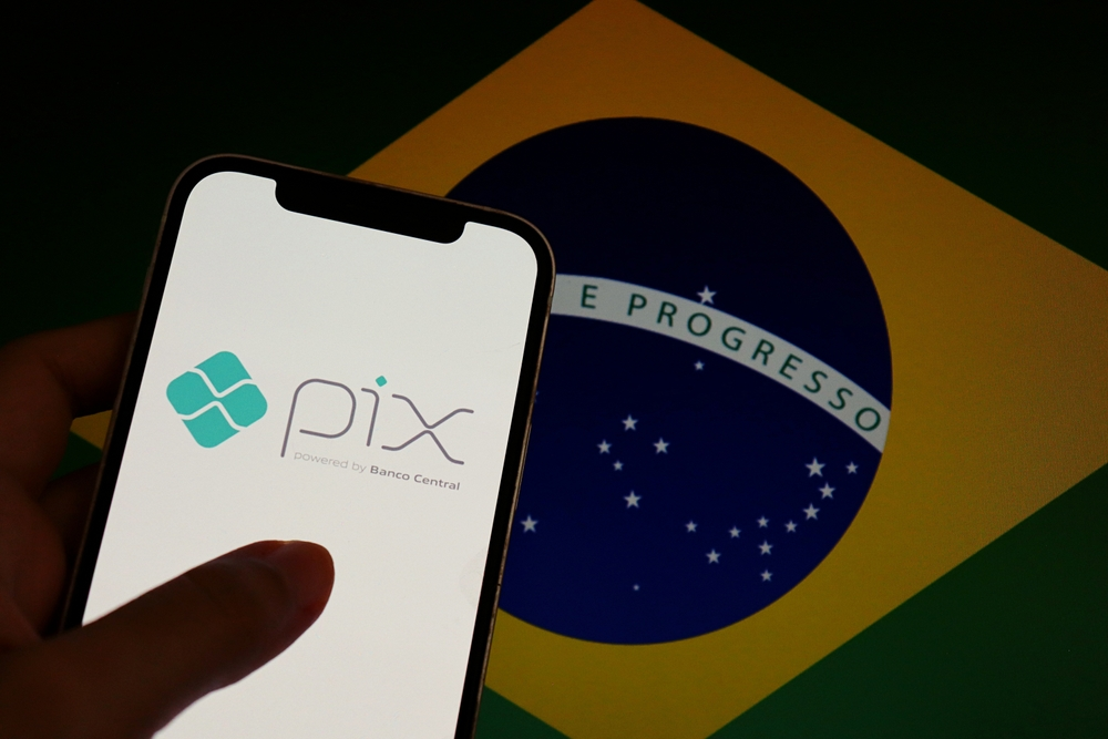 Pantalla de smartphone mostrando el logo oficial de PIX del Banco Central sobre la bandera de Brasil, ilustrando pagos para extranjeros.